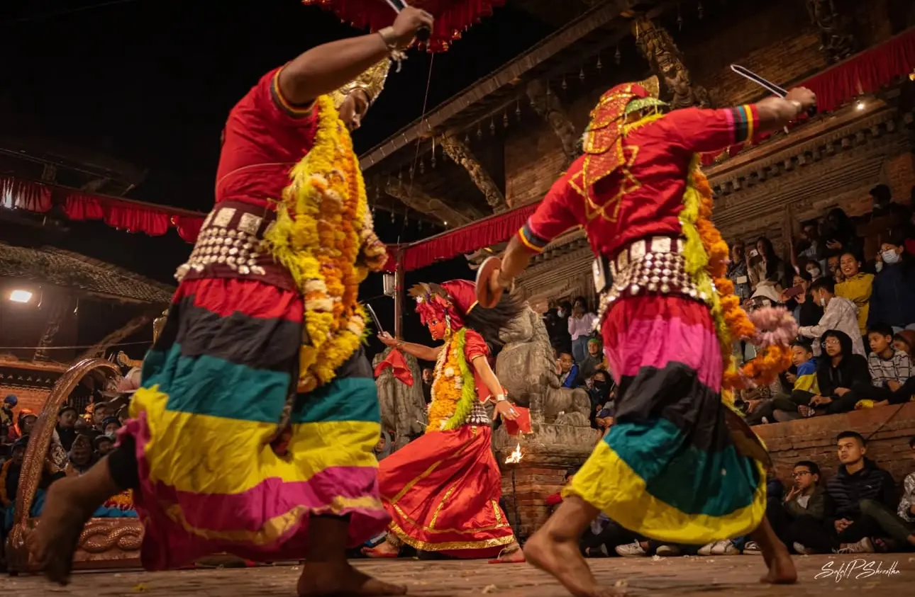 Dancers in striped skirts leap across the stage
